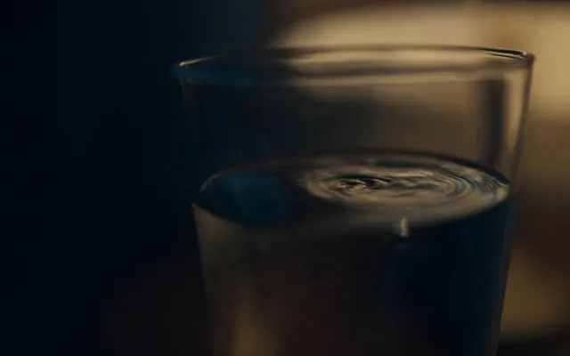 Bicchiere d'acqua con onde concentriche sulla superficie